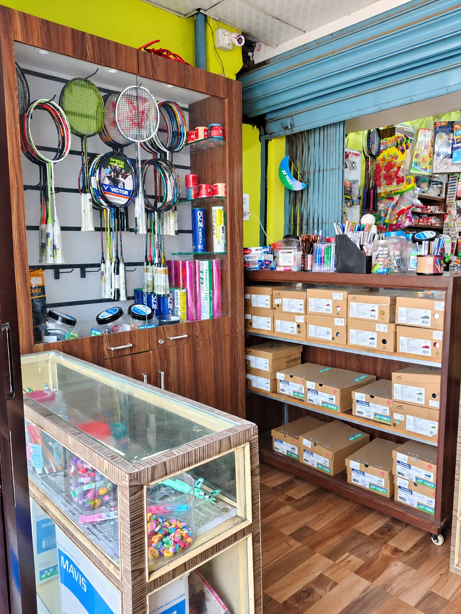 AI-enhanced rendering based on the shop’s badminton rackets, shuttlecocks, grips and sports shoe display; fine product details are illustrative.